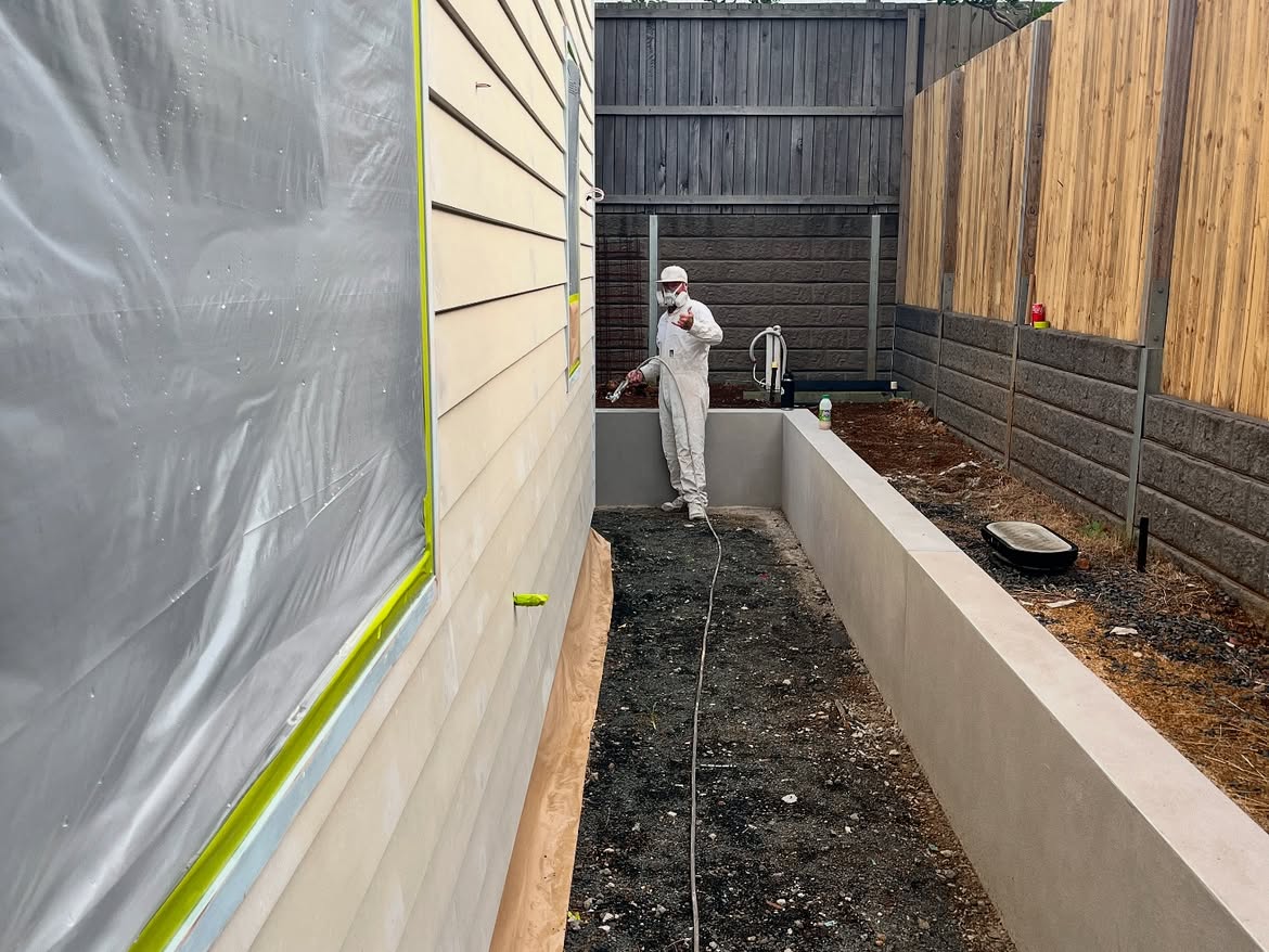 Davidson Painting team spray-painting an exterior wall on a Northern Rivers home
